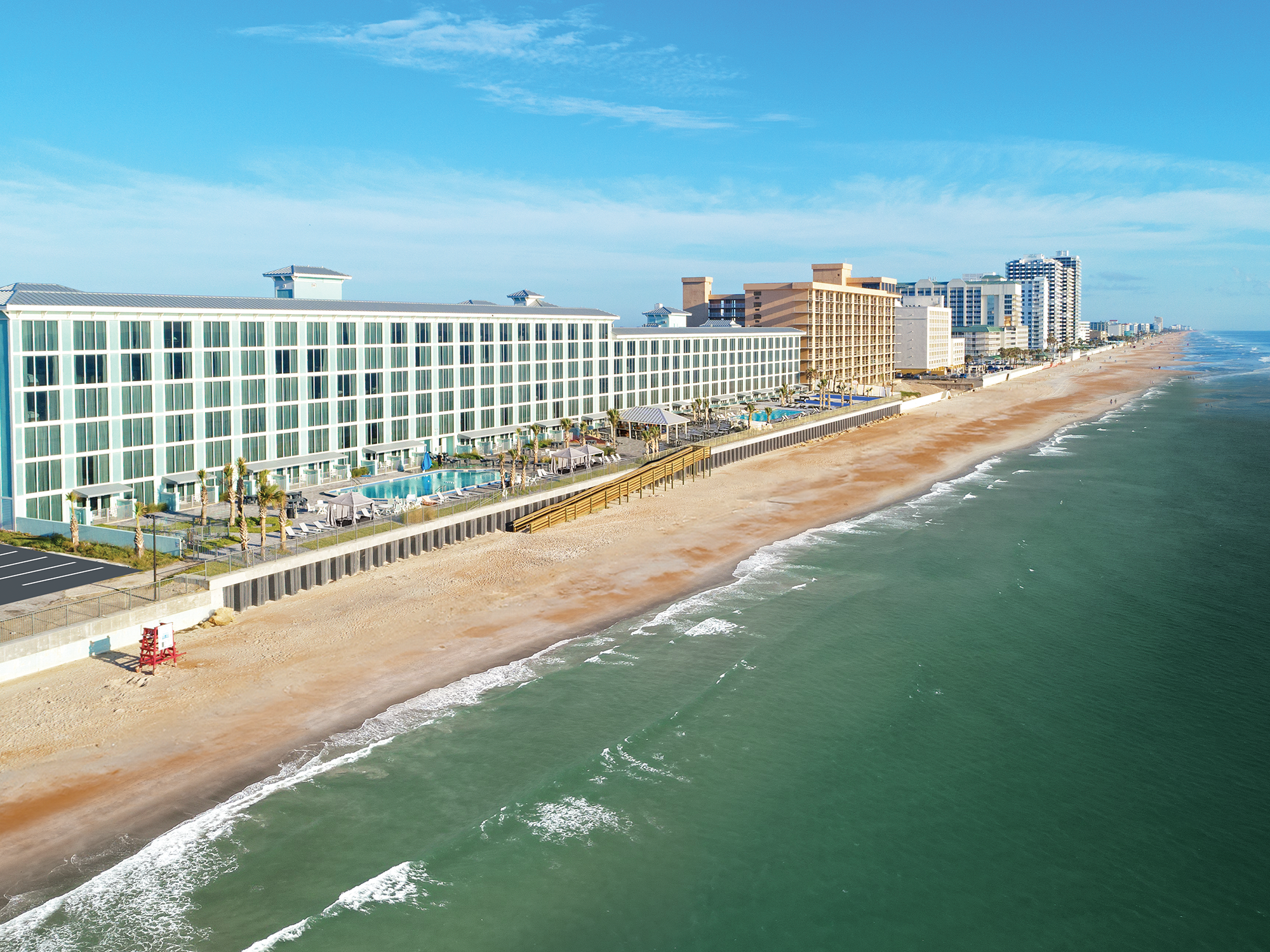 Beachfront of the grand seas daytona beach resort along a coastline with clear blue sky.