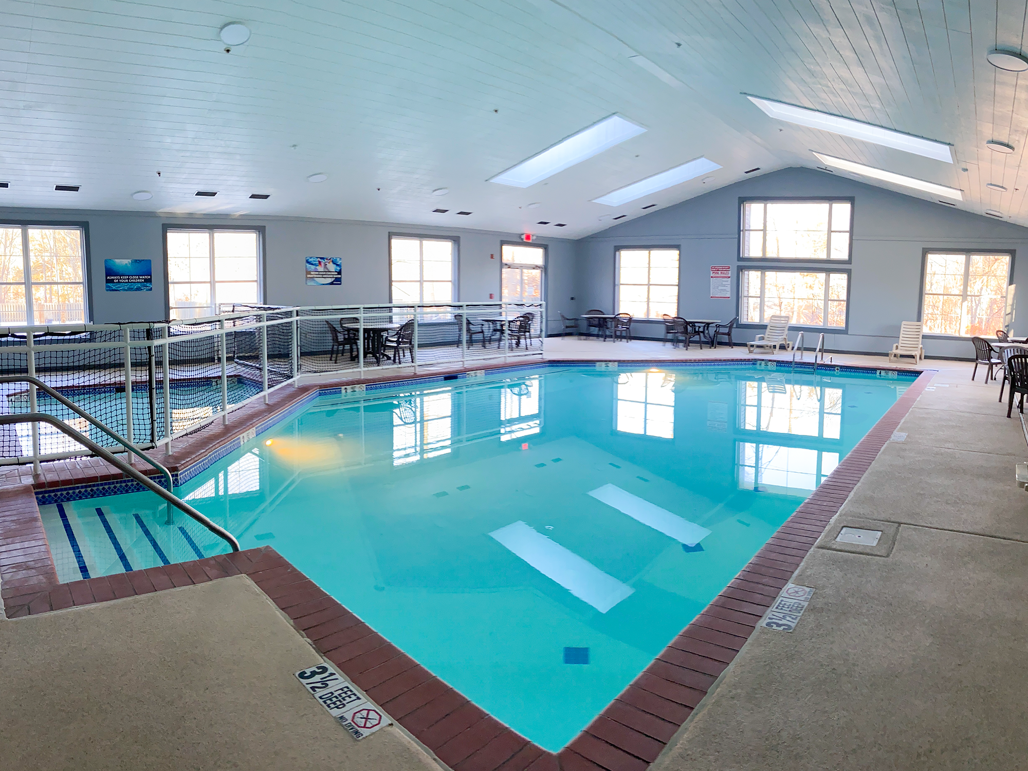 Indoor pool with in a building with large windows and natural light