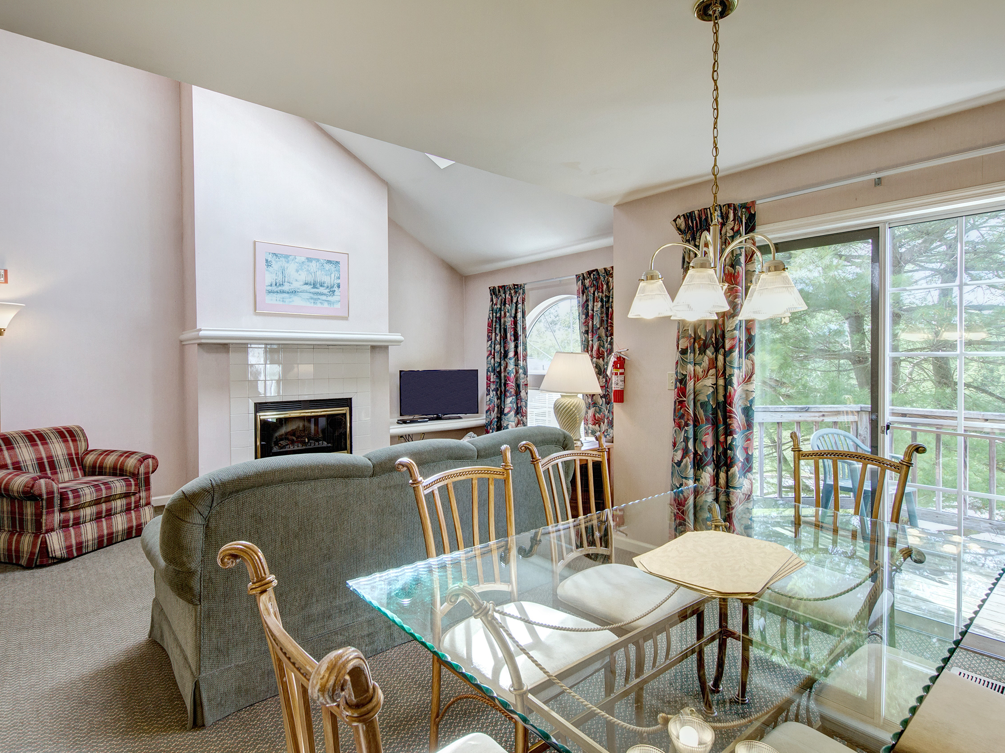 Living room with a fireplace, sofa, and dining table with chairs.