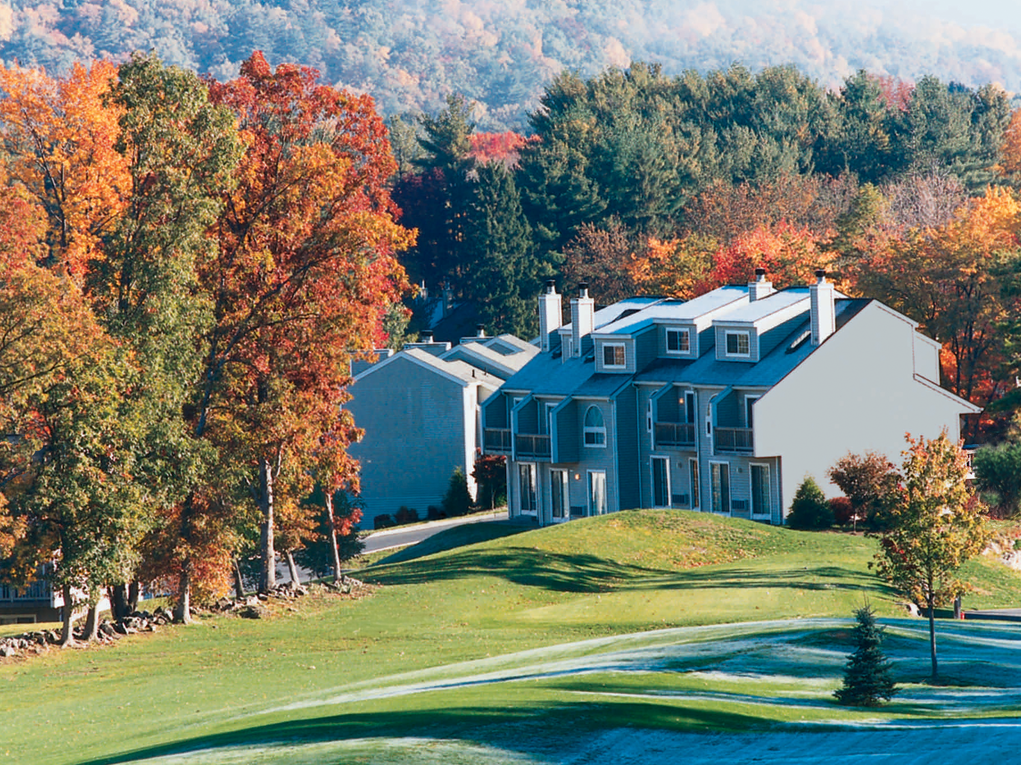 Residential house with a golf course and autumn trees in the background