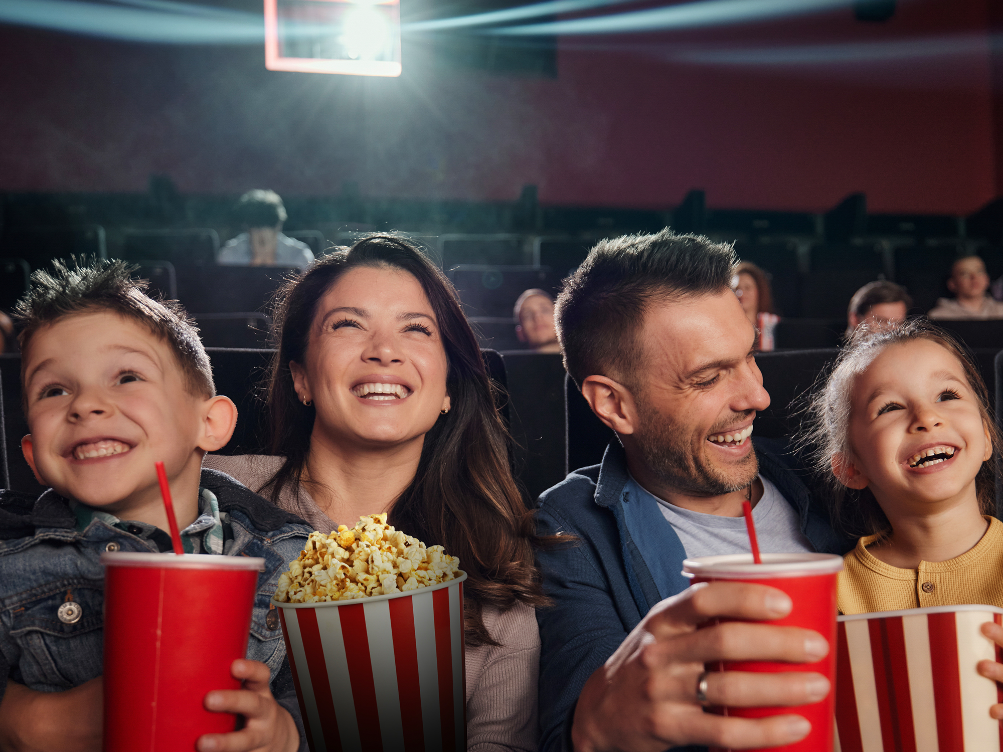 Family enjoying popcorn and drinks in a movie theater